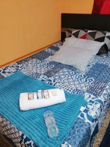 Homestay Mama Tuch في سان بيدرو لا لاغونا: سرير عليه منشفتين وزجاجة