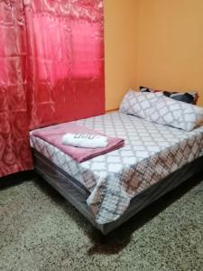 Homestay Mama Tuch في سان بيدرو لا لاغونا: سرير صغير في غرفة بجدار احمر