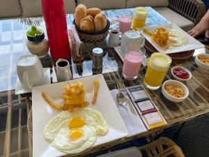 un tavolo per la colazione con uova, patatine fritte e bevande di Hotel Rupa Rupa a Tingo María