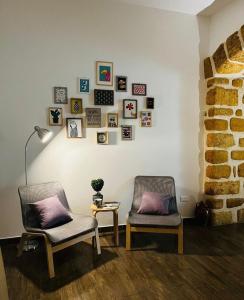 Deux chaises dans une pièce avec des photos sur le mur dans l'établissement La Casa di Ninì, à Agrigente