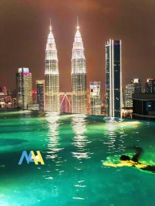 - une piscine avec vue sur la ville la nuit dans l'établissement Eaton residences KLCC m@h, à Kuala Lumpur