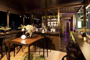a restaurant with a bar with tables and chairs at Baglioni Signature in Ho Chi Minh City