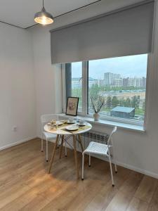 a dining room with a table and chairs and a window at Cozy Urban Retreat in Prigorodnyy