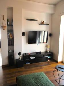 a living room with a flat screen tv on a wall at Rooftop Appia antica, Attico silenzioso residenziale in Rome