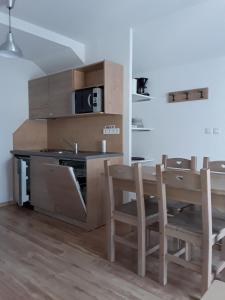 - une cuisine et une salle à manger avec une table et un four micro-ondes dans l'établissement Résidence de Tourisme La Meije Blanche, à Villar-dʼArêne 83 autres photos