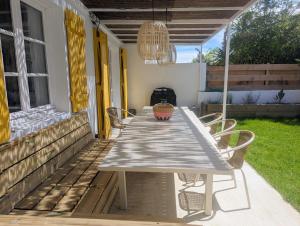 una mesa en el porche trasero de una casa en Maison de pêcheur à 10 minutes à pied de Saint Jean de Luz, en Ciboure