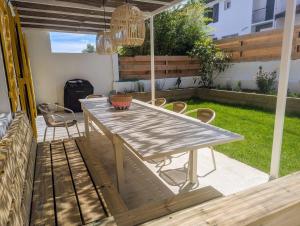 Una mesa y sillas de madera en un patio. en Maison de pêcheur à 10 minutes à pied de Saint Jean de Luz, en Ciboure