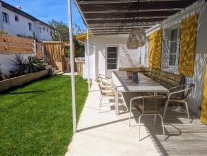 un patio con mesa y sillas bajo una pérgola en Maison de pêcheur à 10 minutes à pied de Saint Jean de Luz, en Ciboure