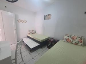 a small room with a table and a bed and a desk at Casa de Campina in Campina Grande