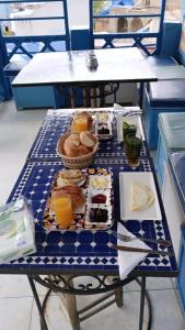 USHA Guest House في شفشاون: طاولة عليها أطباق من المواد الغذائية والمشروبات