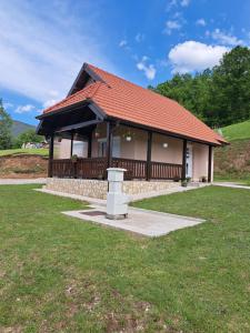 una pequeña casa con techo rojo en Mokrogorska kuca en Mokra Gora