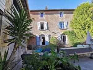 a house with a palm tree in front of it at Les chambres de Cherveux in Cherveux