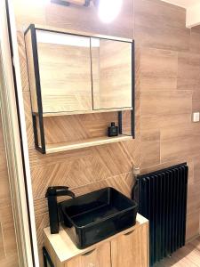 a bathroom with a black sink and a mirror at Ma Montagne Chic 4 in La Bresse