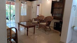 a living room with chairs and a table and a fireplace at Eden Thottam Homestay in Kattappana