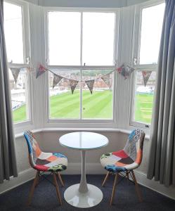 2 sillas y una mesa frente a una ventana en Ainsley Court Guest House, en Scarborough
