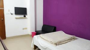 Habitación hospital con cama y pared púrpura en HOTEL MOHSIN PLAZA, en Sreemangal