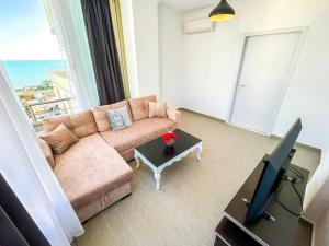 ein Wohnzimmer mit einem Sofa und einem TV in der Unterkunft Seraphic Suites 668 in Durrës
