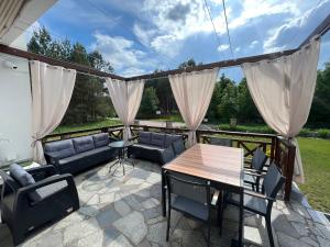 eine Terrasse mit einem Holztisch und Stühlen in der Unterkunft Zakole Brdy in Gostyczyn