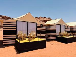 a group of tents with chairs in the desert at Desert Bedouin adventure in Wadi Rum