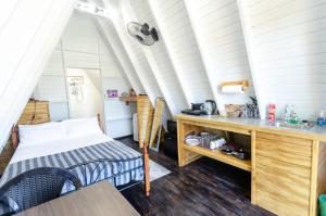 Habitación pequeña con cama y escritorio. en Cashaw Cabin - Private A-frame Treasure Beach en Treasure Beach