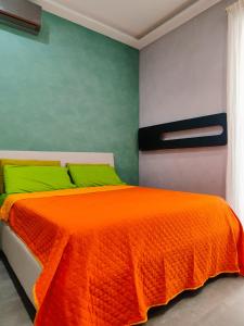 ein Schlafzimmer mit einem orangenen Bett und grünen Kissen in der Unterkunft Gians B&B in Neapel