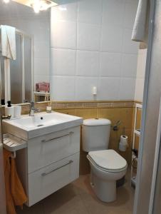 ein Badezimmer mit Toilette, Waschbecken und Spiegel in der Unterkunft La Cabaña de la Antilla II in La Antilla