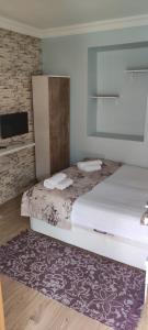 a bedroom with a bed with a mirror and a rug at LAVİNYA PENSİON in Kusadası