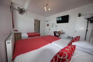 a bedroom with two beds with red and white covers at City London Hotel in London