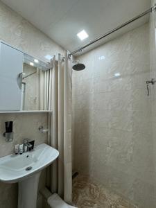 a white bathroom with a sink and a shower at Centroom boutique hotel in Yerevan