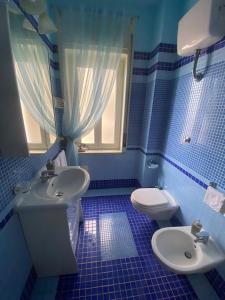 Un baño azul con lavabo e inodoro. en Domus Diocleziano, en Nápoles 12 fotos más