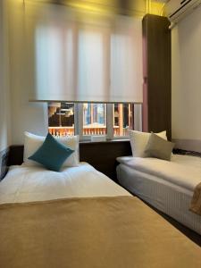two beds in a room with a window at Centroom boutique hotel in Yerevan