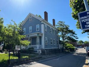 a blue house with a sign in front of it at Beautiful 2-Bedroom, 2-Bath Townhouse in Boston