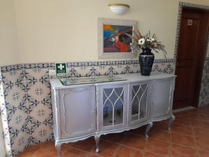 a bathroom with a sink and a vase of flowers at Aurora Sol in Luz