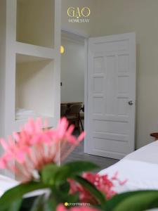 Zimmer mit einer weißen Tür und einer rosa Blume in der Unterkunft Gạo Homestay in Mui Ne