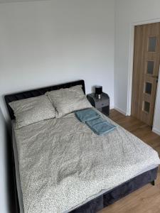 a bed in a bedroom with a white wall at Mallborro - Z widokiem na zamek in Malbork