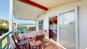 a patio with a table and chairs on a balcony at La Paranthese Marine in Brem-sur-Mer