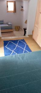 ein Wohnzimmer mit einem blauen Teppich auf dem Boden in der Unterkunft La Maison des Amis in Fès