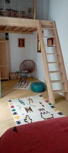 um quarto com um beliche com uma escada e um tapete em La Maison des Amis em Fez