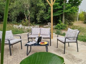 três cadeiras e uma mesa num pátio em Villa Petra em Botrugno