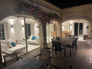 een patio met een tafel en stoelen en een woonkamer bij Le Mas de l'Alliance - 12 p - Air Cond - private Pool - near Grignan in Roussas