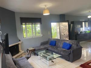 ein Wohnzimmer mit einem Sofa und einem Glastisch in der Unterkunft Βίλα στην Πάτρα in Patras