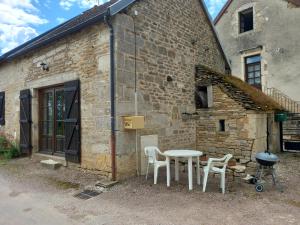 a table and chairs in front of a brick building at Maison studio village médiéval in Mont-Saint-Jean