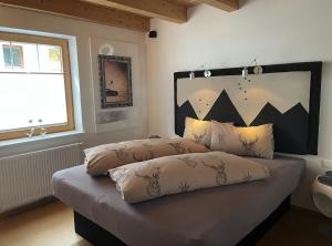 a bedroom with a bed with two pillows on it at Zillertal Residenz in Ginzling
