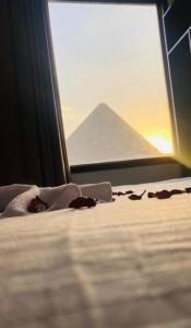 uma cama num quarto com vista para uma pirâmide em Arena pyramids view no Cairo