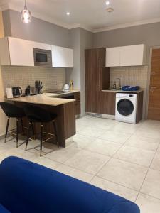 a kitchen with a sink and a washing machine at Avant Garde Luxury Apartment in Accra