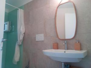 ein Bad mit einem Waschbecken und einem Spiegel in der Unterkunft Bastione home - casa "Vicky" in Cagliari