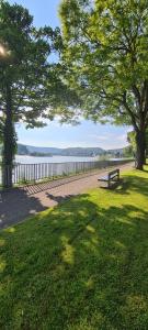 a park with a bench and a fence and a lake at Castello Apartment Boppard in Boppard