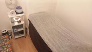 a bed in a corner of a room at Wara in Kingston upon Thames