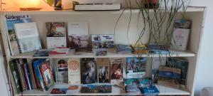 ein Bücherregal mit Büchern und Zeitschriften in der Unterkunft Bastione home - casa "Vicky" in Cagliari
