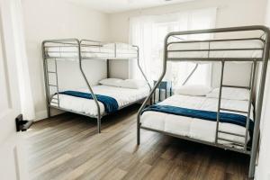 two bunk beds in a room with a wooden floor at Dreamy Palms in Myrtle Beach